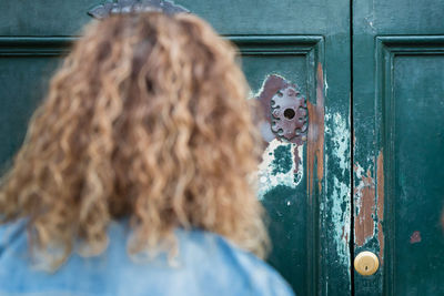 Rear view of woman against closed door