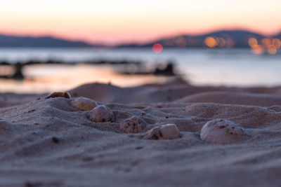 Close-up of rocks on beach against sky during sunset