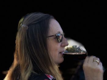 Close-up portrait of a young woman drinking glasses