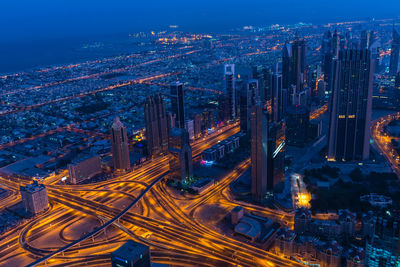 High angle view of illuminated city street and buildings at night