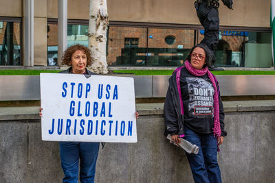 Portrait of woman standing against wall
