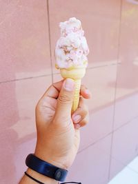 Hand holding ice cream cone on floor