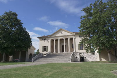 Building by lawn against sky