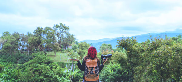 Low angle view of woman standing against trees