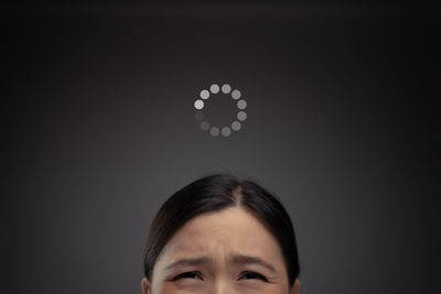 Portrait of a serious young woman over black background