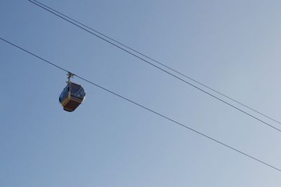 Low angle view of overhead cable car against clear sky