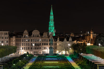 Illuminated buildings in city against sky at night