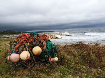 View of fishing net on beach against cloudy sky