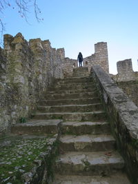 Low angle view of steps amidst buildings against clear sky