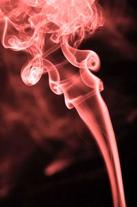 Close-up of red abstract smoke pattern against black background