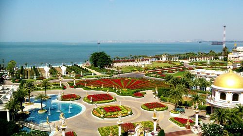 High angle view of formal garden by sea against sky