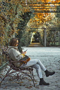 Woman sitting in park during autumn