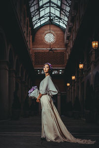 Side view of woman standing corridor of building