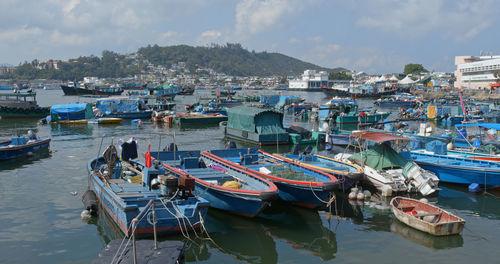 High angle view of fishing boats moored at harbor in city