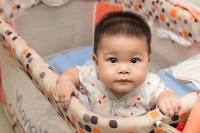 Portrait of cute baby in crib