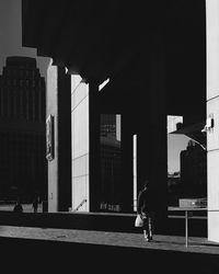 Person walking in city against buildings