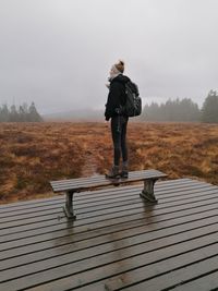 Full length of woman standing on field against sky