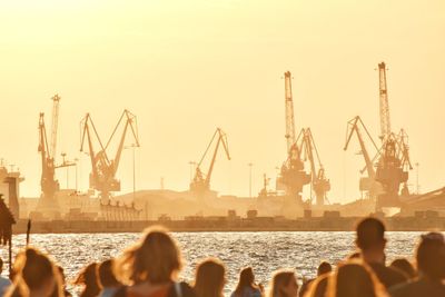 Group of people at commercial dock against clear sky