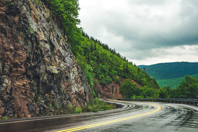 Road amidst trees against sky