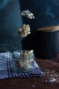 Close-up of glass jar with flying vegan sweets rustic style