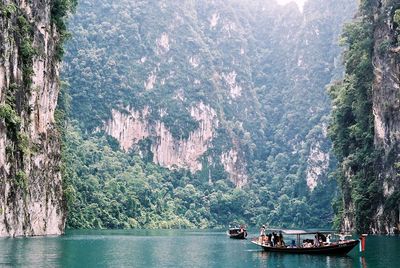 View of boats in sea against mountain range