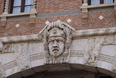 Low angle view of statue against old building