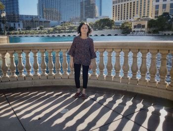 Portrait of woman standing against belcony in city