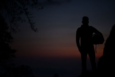 Silhouette man standing on beach against sky during sunset