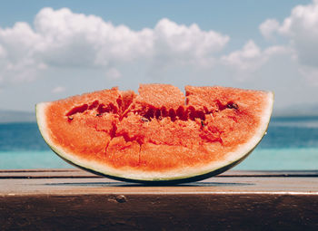 Close-up of fruit on table against sea