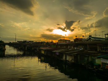 Sunset over river with buildings in background