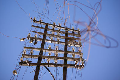 Low angle view of cables against clear blue sky