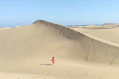Kid walking on sand at desert