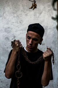 Portrait of young man standing against wall