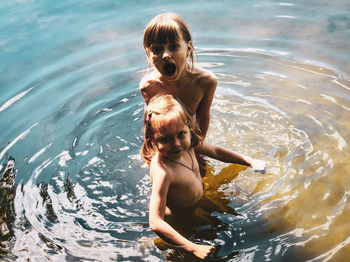 Full length of shirtless a little girls in water