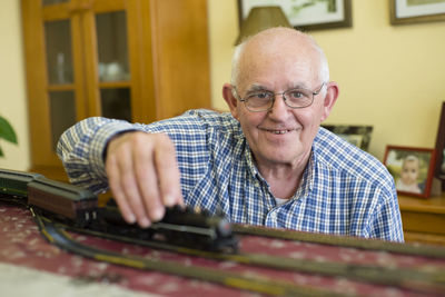Portrait of smiling senior man with his model railway