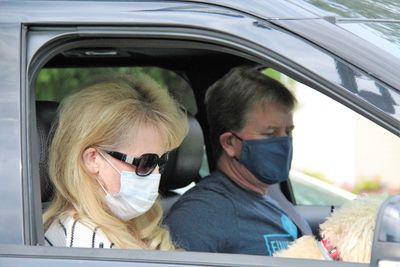 Portrait of couple wearing masks  sitting in car