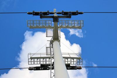 Low angle view of telephone pole against blue sky