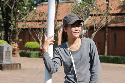 Portrait of young woman wearing sunglasses standing outdoors