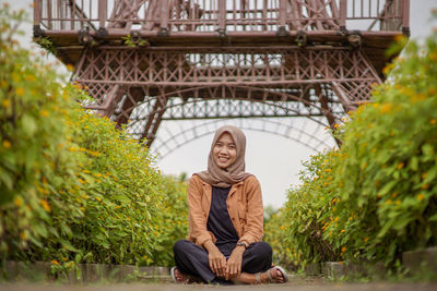 Beautiful asian woman hijab muslim sitting in flower garden path