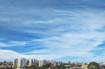 Buildings in city against cloudy sky