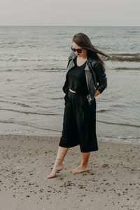 Full length of young woman standing on beach