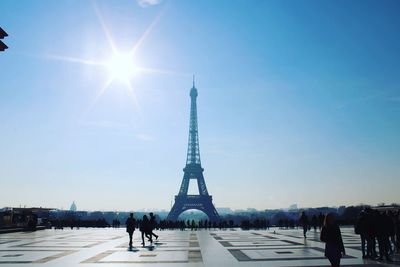 People walking on tower in city against sky