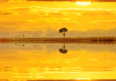 Scenic view of lake against orange sky
