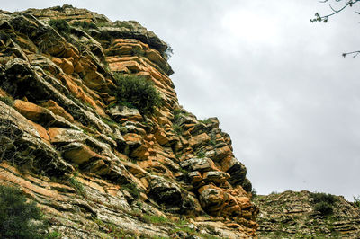 Low angle view of rock formation on mountain against sky