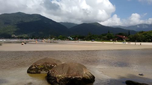 Panoramic view of people on beach against sky