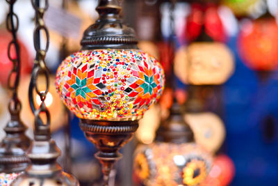 Close-up of electric lamp hanging at market stall