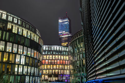 Low angle view of illuminated buildings against sky at night