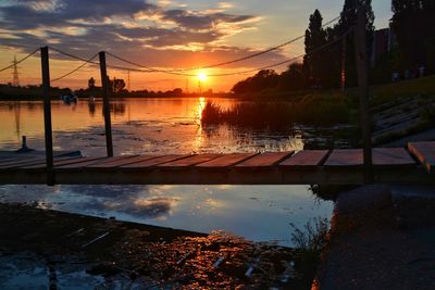 Scenic view of river against sky at sunset