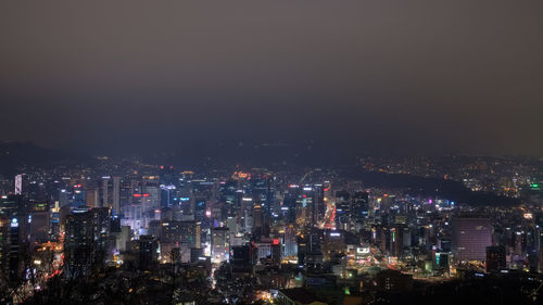 High angle view of illuminated cityscape against sky at night