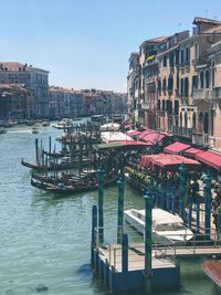 Boats moored at canal against buildings in city